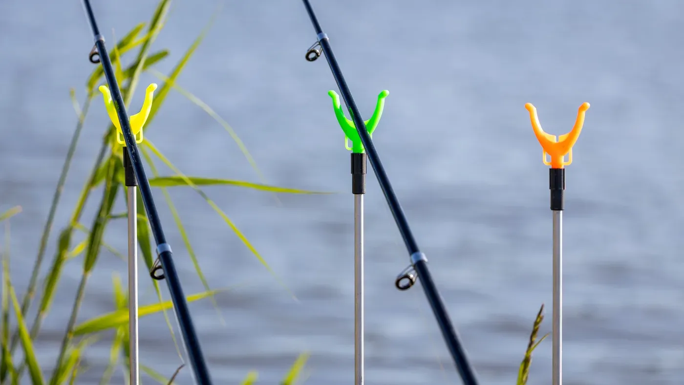 Fiskespön i hållare i rad vid vattnet